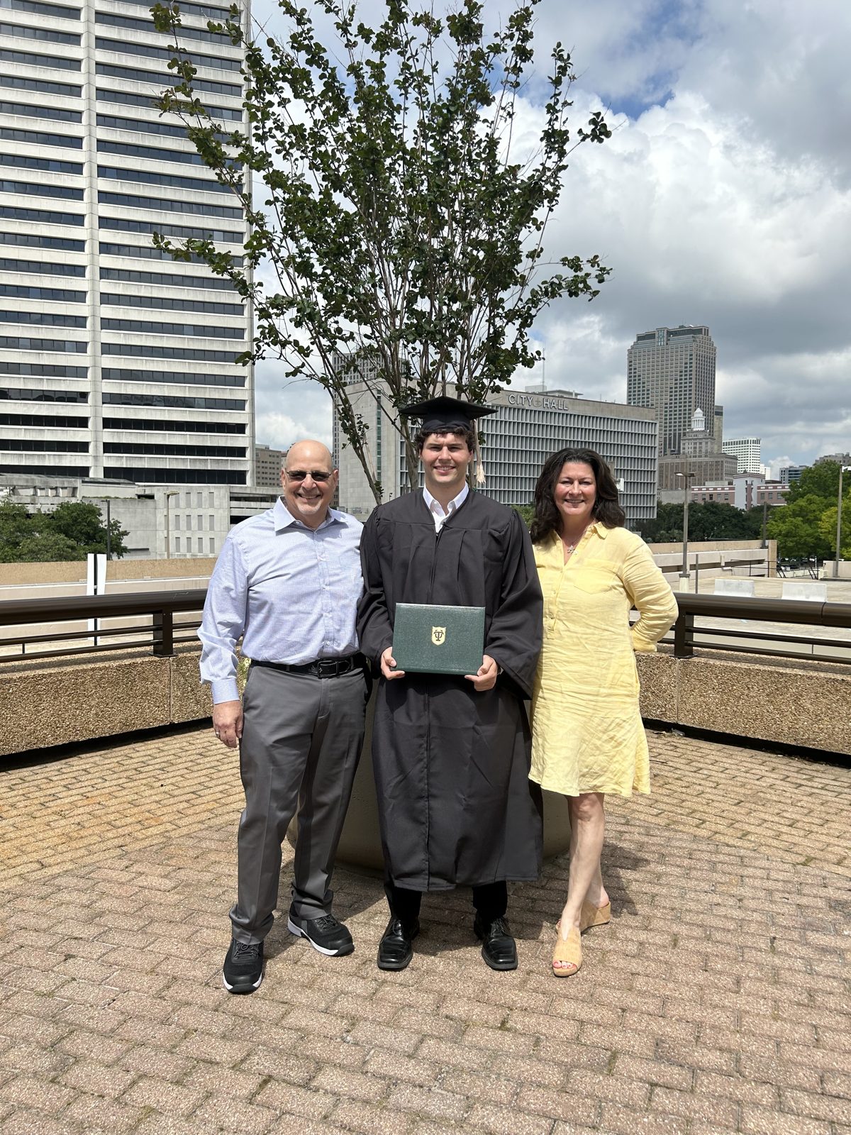 Graduation day downtown in cap and gown with family