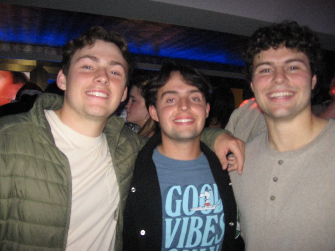 Three friends smiling at a bar