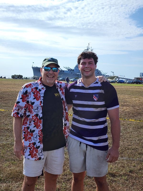 Two people on an open field by the water